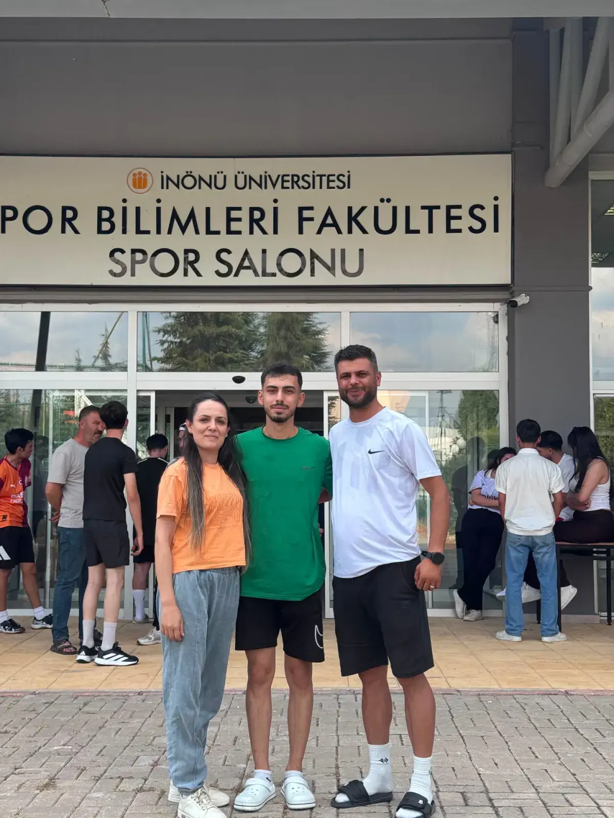 Yeşilova Spor Akademisi eğitmenleri öğrencisiyle sınav alanında poz verirken